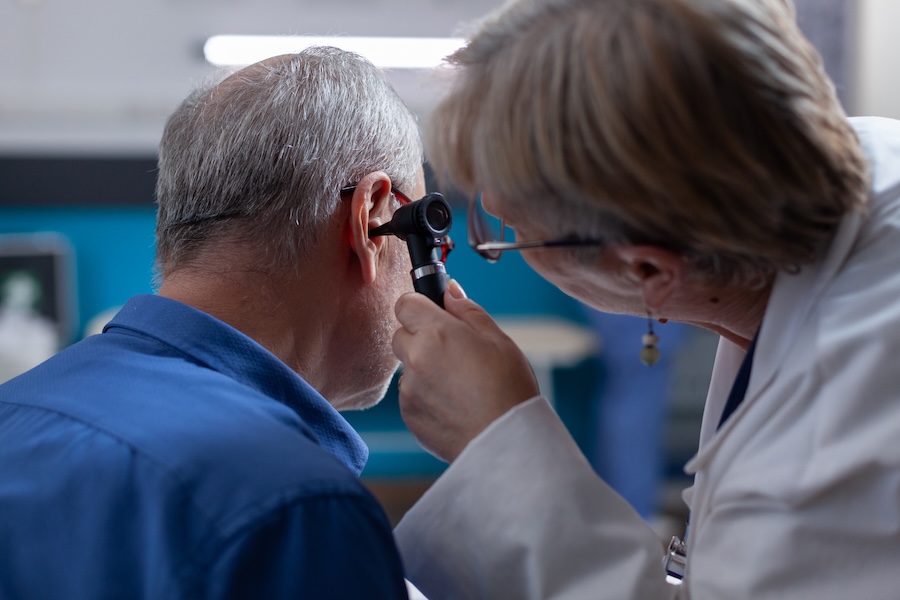 doctor holding otoscope to do ear consultation